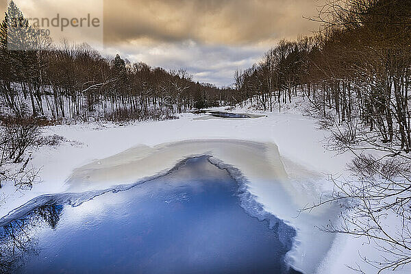 Ruhige Winterlandschaft mit Spiegelungen im Wasser und Schneeverwehungen  Laurentides; Quebec  Kanada