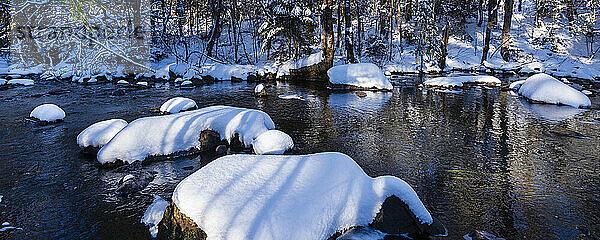 Ruhige Winterlandschaft mit Spiegelungen im Wasser und Schneehügeln  Laurentides; Quebec  Kanada