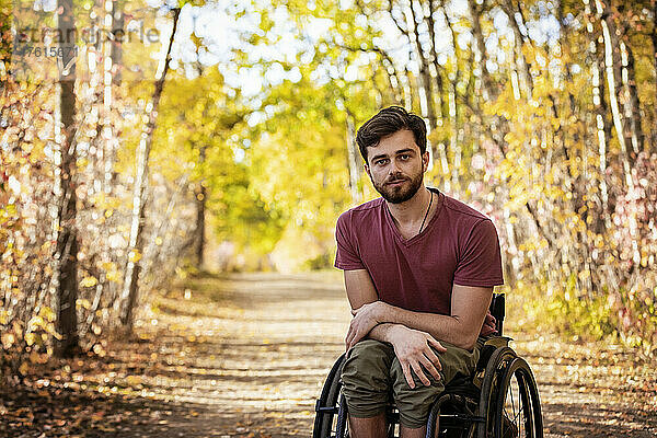 Porträt eines querschnittsgelähmten Mannes in einem Rollstuhl im Freien in einem Park im Herbst; Edmonton  Alberta  Kanada