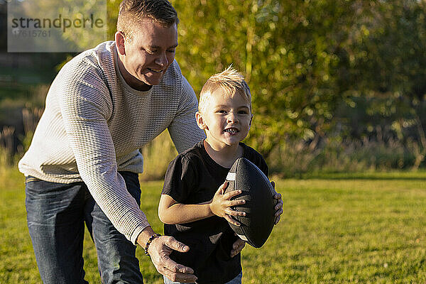 Vater spielt Fußball mit seinem kleinen Sohn in einem Park im Herbst; St. Albert  Alberta  Kanada