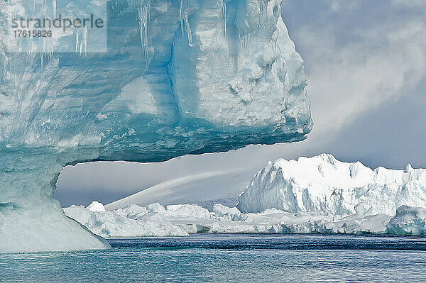 Abstrakte Form eines Eisbergs mit blauen Eisschatten und türkisfarbenem Wasser des Südlichen Ozeans bei Cierva Cove in der Hughes Bay; Antarktische Halbinsel  Antarktis