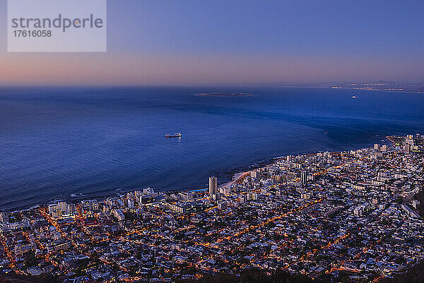 Überblick über die Skyline von Kapstadt und die Küstenlinie entlang des Atlantischen Ozeans in der Abenddämmerung; Kapstadt  Westkap-Provinz  Südafrika