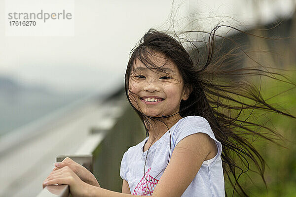 Außenporträt eines Mädchens mit vom Wind verwehtem Haar; Hongkong  China