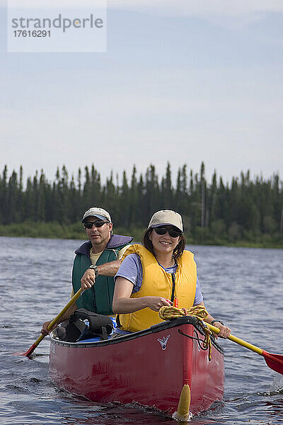 Ein Paar paddelt mit einem Kanu auf einem Fluss; Winisk River  Ontario  Kanada.