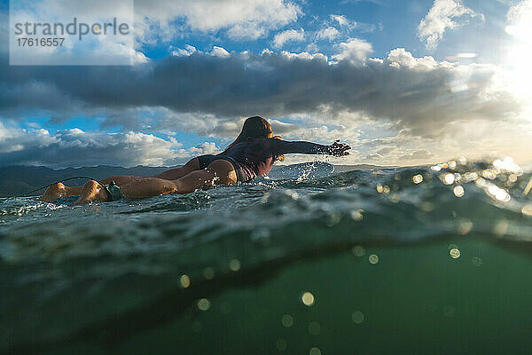 Eine Frau beim Surfen an der Nordküste von Hawaii.