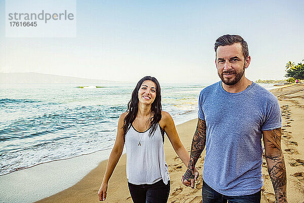 Porträt eines Paares  das händchenhaltend am Strand von Ka'anapali entlanggeht; Ka'anapali  Maui  Hawaii  Vereinigte Staaten von Amerika
