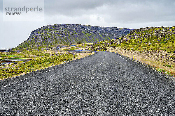 Gepflasterte Straße in der Fjordlandschaft des Vestfjardarvegur-Pfades im Sommer; Vestfjardarvegur  Westfjorde  Island