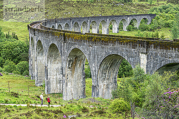 Zwei Wanderer gehen in Richtung des Viadukts bei Glenfinnan  Schottland; Glenfinnan  Inverness-shire  Schottland