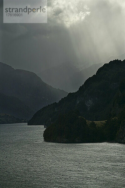 Lago Elizalde  mit Sonnenstrahlen  die durch Gewitterwolken scheinen  in der Nähe von Coyhaique in Chile; Patagonien  Chile