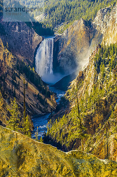 Sonnenbeschienenes schwefelhaltiges Gestein der Klippen  die die Lower Falls des Yellowstone River im Grand Canyon of the Yellowstone umgeben; Yellowstone National Park  Wyoming  Vereinigte Staaten von Amerika