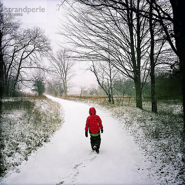 Ein neunjähriger Junge läuft auf einer schneebedeckten Straße in der Nähe des Skigebiets Timberland; Canaan Valley  West Virginia.