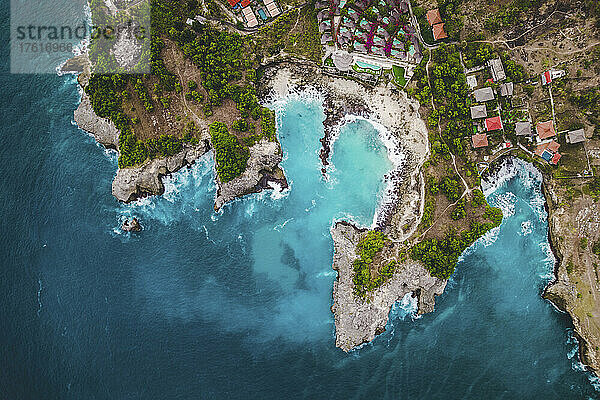 Blick von oben auf die felsige Küste und die Strandpromenade des Ferienortes Lembongan mit Gebäuden am Rande des türkisfarbenen Wassers vor der Küste von Bali; Nusa-Inseln  Regentschaft Klungkung  Ost-Bali  Indonesien