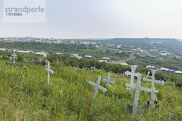 Kreuze markieren den Dorffriedhof auf dem Hügel über dem Mountain Village im Sommer; Lower Yukon River  Westalaska  Vereinigte Staaten von Amerika