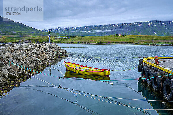 Buntes Beiboot  festgemacht an einem Steg im Hafen von Hauganes in der nördlichen Region Islands im Sommer; Hauganes  Nordurland Eystra  Island