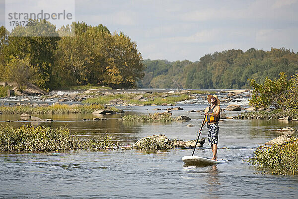 Ein Mann auf einem Stand Up Paddle Board auf dem Potomac River in Bethesda  Maryland.