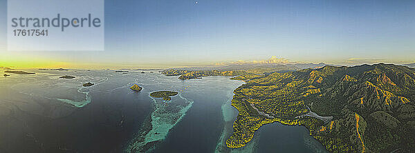 Luftaufnahme der Komodo-Inseln mit leuchtend gelbem Sonnenlicht am Horizont  Komodo-Nationalpark  Heimat des berühmten Komodo-Drachen; Ost-Nusa Tenggara  Kleine Sunda-Inseln  Indonesien