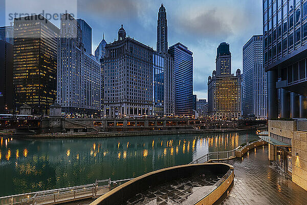 Blick auf die Überquerung des Chicago River und das Stadtbild mit ikonischen Bürotürmen  mit 333 North Michigan  dem London Guarantee Building  dem Mather Tower  dem 35 East Whacker Building und dem Kemper Building in der Stadt Chicago an einem regnerischen Abend; Chicago  Cook County  Illinois  Vereinigte Staaten von
Amerika