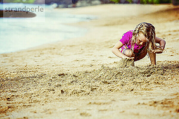 Ein junges Mädchen spielt im Sand an einem Strand in Ka'anapali; Ka'anapali  Maui  Hawaii  Vereinigte Staaten von Amerika