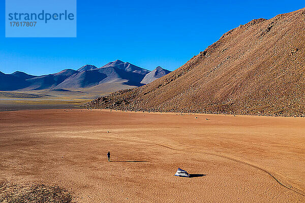 Eine Frau auf dem Weg zurück zu ihrem Zelt in einem trockenen Seebett in 15.000 Fuß Höhe in der Atacama-Wüste.