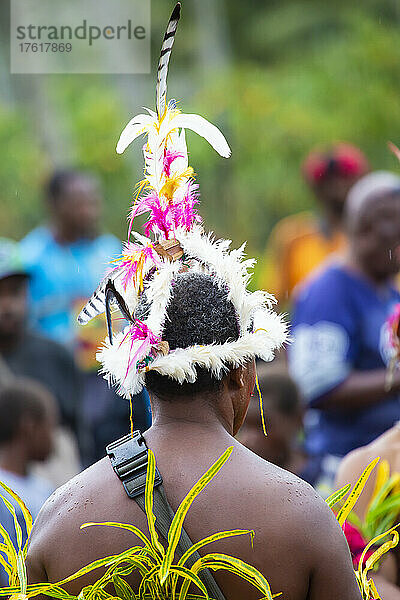 Blick von hinten auf eine traditionelle Tänzerin mit einem Kopfschmuck aus tropischen Vogelfedern bei einer Aufführung auf der Insel Karkar in der Bismarcksee vor der Nordküste von Papua-Neuguinea; Insel Karkar  Provinz Madang  Papua-Neuguinea