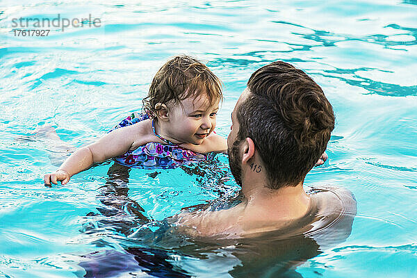 Ein Vater schwimmt mit seiner kleinen Tochter im Pool eines Resorts in Ka'anapali; Ka'anapali  Maui  Hawaii  Vereinigte Staaten von Amerika