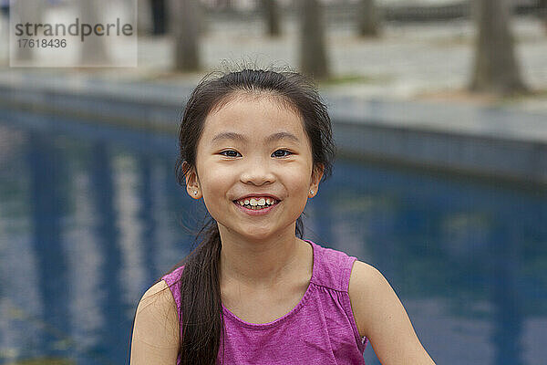 Außenporträt eines Mädchens mit Wasser im Hintergrund; Hongkong  China