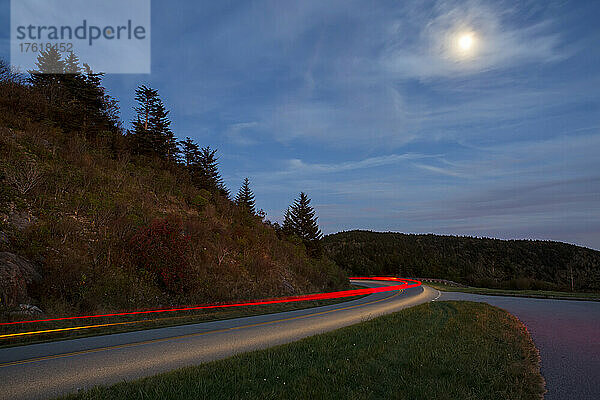 Im Mondlicht ziehen die Rücklichter von Autos auf dem Blue Ridge Parkway in den Blue Ridge Mountains in North Carolina  USA  vorbei; North Carolina  Vereinigte Staaten von Amerika