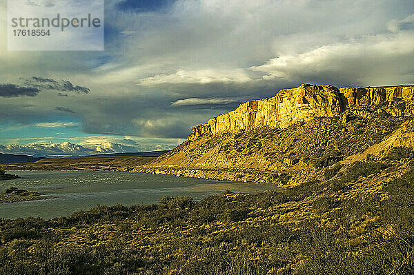 Der Rio La Leona fließt durch die patagonische Steppe mit ihrer kargen Landschaft und der berühmten Nationalstraße 40 bei böigem Sonnenlicht in der Nähe von El Calafate in der Provinz Santa Cruz; Patagonien  Argentinien