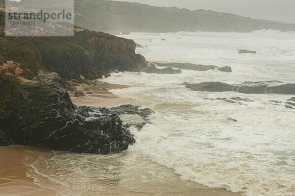 Nebel über dem Strand und der zerklüfteten Küstenlinie des Praia do Malhao; Alentejo  Portugal