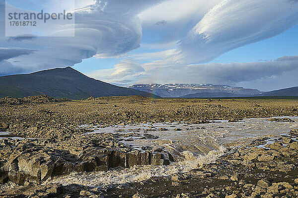 Gletscherfluss  der durch die Basaltlandschaft fließt  mit einem dramatisch bewölkten Himmel entlang des Kaldidalur-Tals; Husafell  Nordurland Vestra  Island