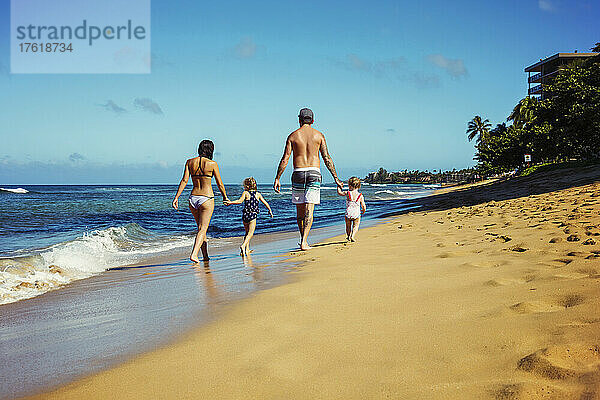 Blick von hinten auf eine Familie mit zwei kleinen Töchtern  die gemeinsam am Ka'anapali Beach spazieren gehen; Ka'anapali  Maui  Hawaii  Vereinigte Staaten von Amerika