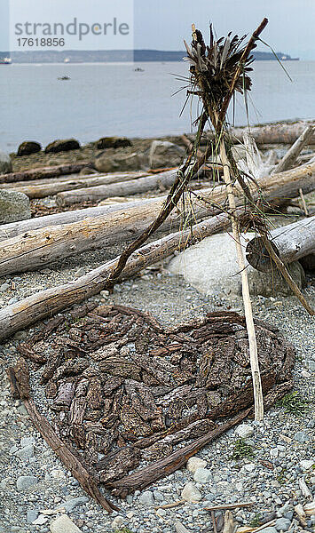 Strandkunst  ein mit Treibholzstücken gezeichnetes Herz zwischen den Baumstämmen am Ambleside Beach in West Vancouver; Vancouver  British Columbia  Kanada