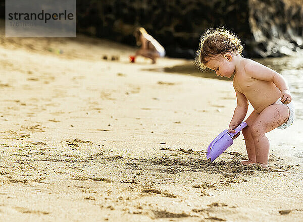 Ein kleines Mädchen in einer Windel spielt am Strand von Ka'anapali mit einer Schaufel; Ka'anapali  Maui  Hawaii  Vereinigte Staaten von Amerika