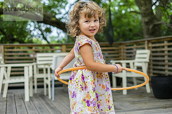 Vorschulmädchen spielt mit Hula-Hoop-Reifen und schaut in die Kamera; Toronto  Ontario  Kanada