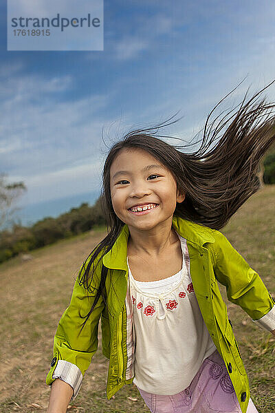 Junges Mädchen rennt auf die Kamera zu  wobei ihr langes Haar hinter ihr herausfliegt; Hongkong  China