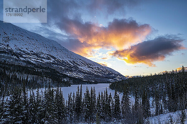Schneebedeckte Landschaft mit schönem Sonnenaufgang über dem Spirit Lake im Winter; Carcross  Yukon  Kanada