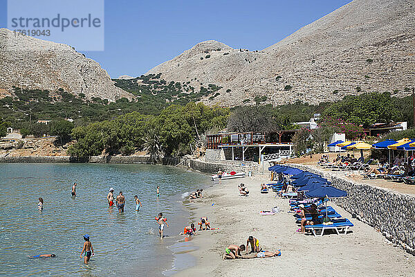 Sonnenanbeter und Schwimmer am Strand von Pontamos auf der Insel Halki  Griechenland; Halki  Dodekanes  Griechenland