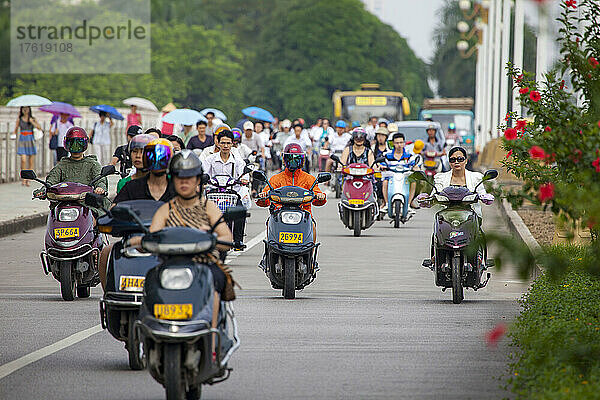 Menschen  die frühmorgens auf Fahrrädern und Motorrollern auf einer separaten Spur in der Stadt Nanning  Guangxi  Südwestchina  pendeln; Nanning  Guangxi  China