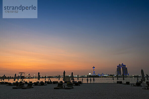 Ein Beach Club unter der untergehenden Sonne im Persischen Golf mit Blick auf die Insel Marina; Abu Dhabi  Vereinigte Arabische Emirate