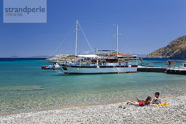 Sonnenanbeter am Strand von Sesklia auf der Insel Symi in Griechenland; Symi  Dodekanes  Griechenland
