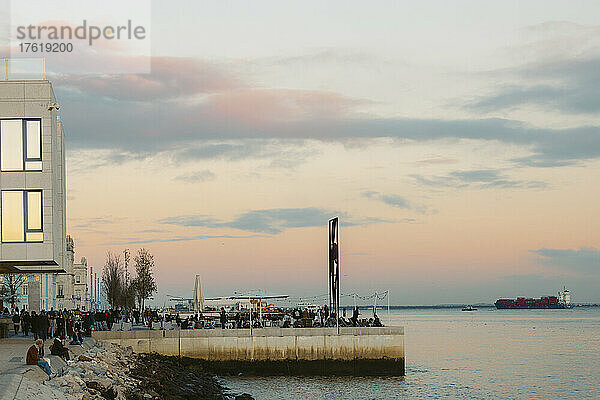 Menschen genießen die Uferpromenade in der Abenddämmerung entlang der Küste von Lissabon; Lissabon  Portugal