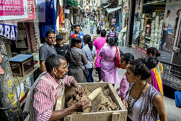 Verkäufer beim Feilschen mit Einkäufern und Fußgängern auf einer Straße in Indien; Amritsar  Punjab  Indien