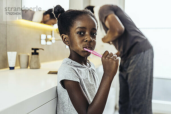 Mädchen putzt sich im Badezimmer die Zähne