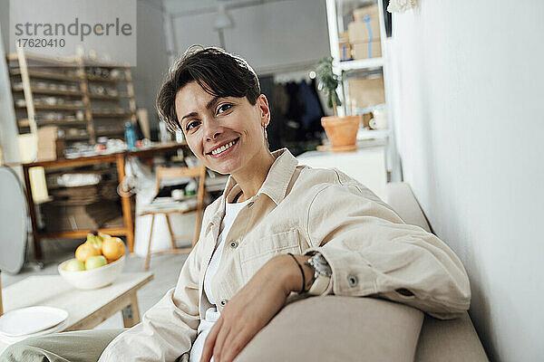 Smiling entrepreneur sitting in ceramics store