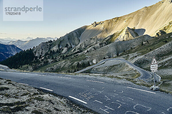 Schild auf der Straße an den Bergen bei Sonnenuntergang  Col d'Izoard  Arvieux  Frankreich