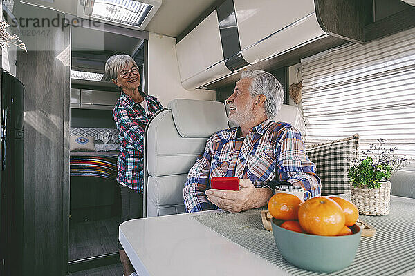 Glückliches Seniorenpaar unterhält sich und reist im Wohnmobil