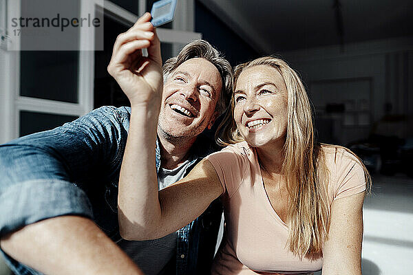 Lächelndes Paar beim Betrachten eines Fotodias