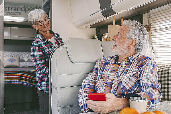 Smiling senior man talking with woman in motor home