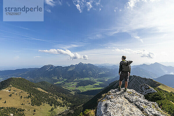Männlicher Wanderer  der die Aussicht vom Gipfel des Aiplspitz-Berges bewundert