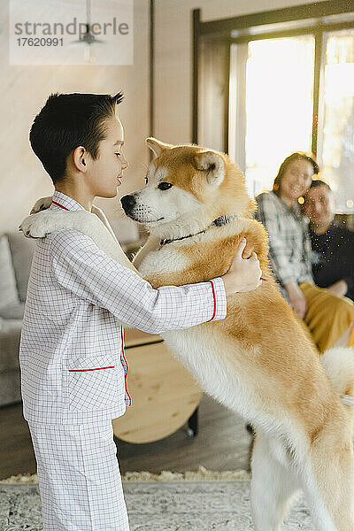 Junge spielt zu Hause mit Hund